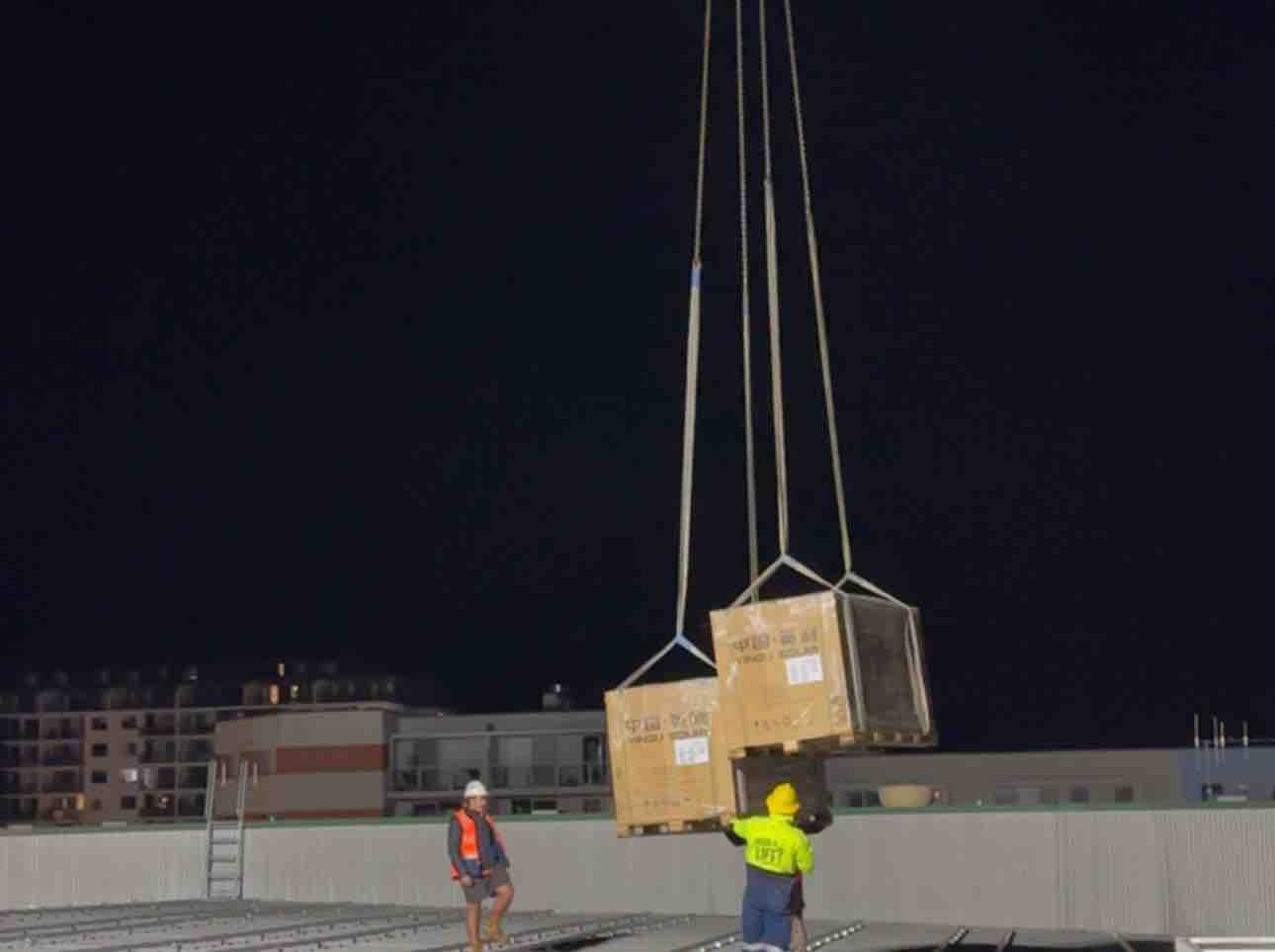 Night crane lift during construction of a commercial energy installation